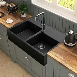 Photo of a kitchen with a white countertop and a black sink