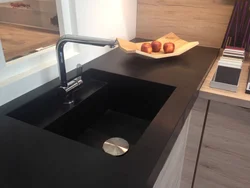 Kitchen sinks built into countertops made of artificial photo