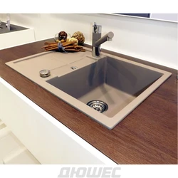 Kitchen sinks built into countertops made of artificial photo