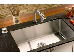 Kitchen sinks built into countertops made of artificial photo