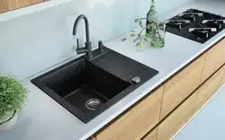 Kitchen sinks built into countertops made of artificial photo