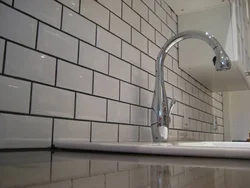 Grout on white tiles in the kitchen photo