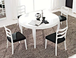 Белы стол з чорнымі крэсламі ў інтэр'еры кухні