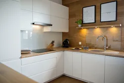 White kitchen in the interior with a wooden countertop real photos