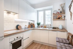 White kitchen in the interior with a wooden countertop real photos