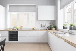White kitchen in the interior with a wooden countertop real photos