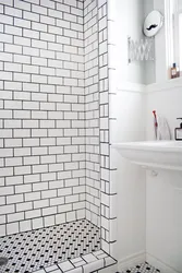 White bathtub with black grout photo