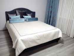 Кровать с покрывалом в интерьере спальни
