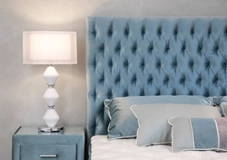 Turquoise bed in a bedroom interior with a soft headboard