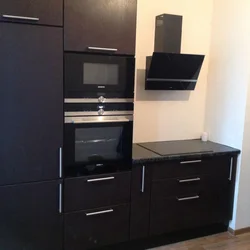 Photo of a kitchen with built-in oven and microwave