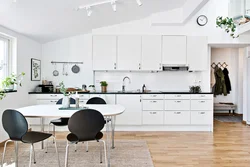 White kitchen with wooden countertop and black handles in the interior