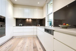 Белая кухня с деревянной столешницей и черными ручками в интерьере