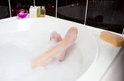 Photo of feet in a bathtub covered in foam