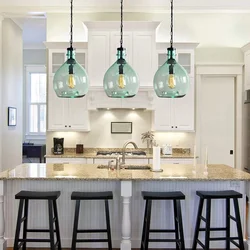 Pendant lamps above the bar counter in the kitchen in the interior