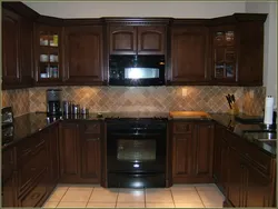 Photo Of An Oak Kitchen With A Dark Countertop