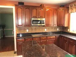 Photo of an oak kitchen with a dark countertop