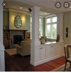 Columns in the interior of a living room with a kitchen