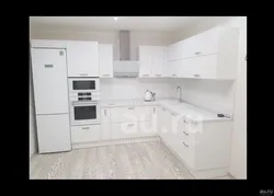 White kitchen with white countertops and white appliances photo