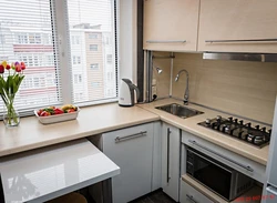 Corner kitchen design photo with refrigerator by the window