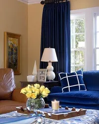 Синий диван и синие шторы в интерьере гостиной