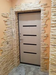 Finishing doors with decorative stone in the hallway photo