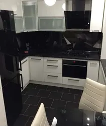 Photo of a kitchen with a black countertop and a black refrigerator