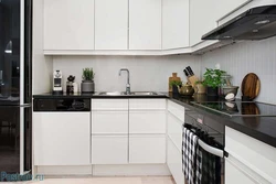 Photo of a kitchen with a black countertop and a black refrigerator