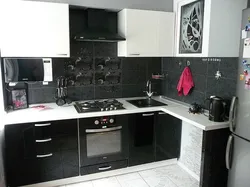 Photo of a kitchen with a black countertop and a black refrigerator
