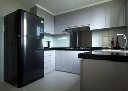 Photo of a kitchen with a black countertop and a black refrigerator