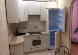 Corner kitchen with refrigerator and gas stove photo