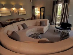 Дөңгелек диванның интерьері бар қонақ бөлмесінің фотосуреті