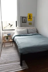 Bed along the wall in a small bedroom design