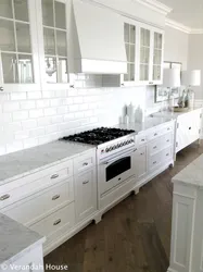 Marble countertop and splashback in a white kitchen photo