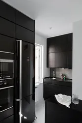 Black Refrigerator In The Interior Of A White Kitchen