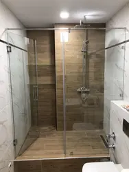 Photo of a bathtub with a shower screen without a tray