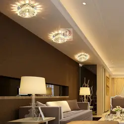 Интерьер гостиной с натяжным потолком и светильниками и люстрой