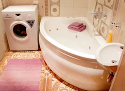 Corner baths in a small bathroom with a washing machine photo