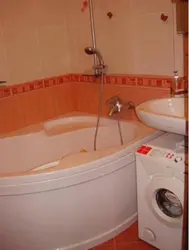 Corner baths in a small bathroom with a washing machine photo