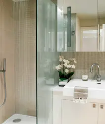 Photo of a bathroom with a shower behind glass