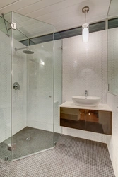 Photo of a bathroom with a shower behind glass