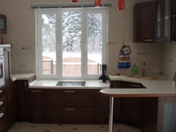 Kitchen design with a window in the middle and a radiator under the window