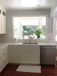 Kitchen design with a window in the middle and a radiator under the window