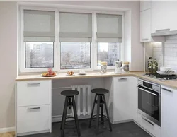 Дизайн кухни с окном посередине и батареей под окном