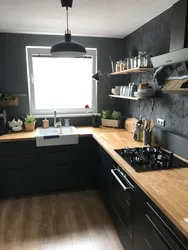 Темная кухня с деревянной столешницей в интерьере