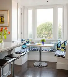Дизайн кухни с диваном и столом у окна