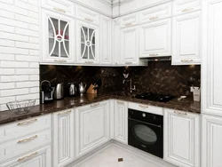 Белая кухня в интерьере с темным фартуком