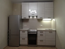 Kitchen on one wall with a refrigerator photo